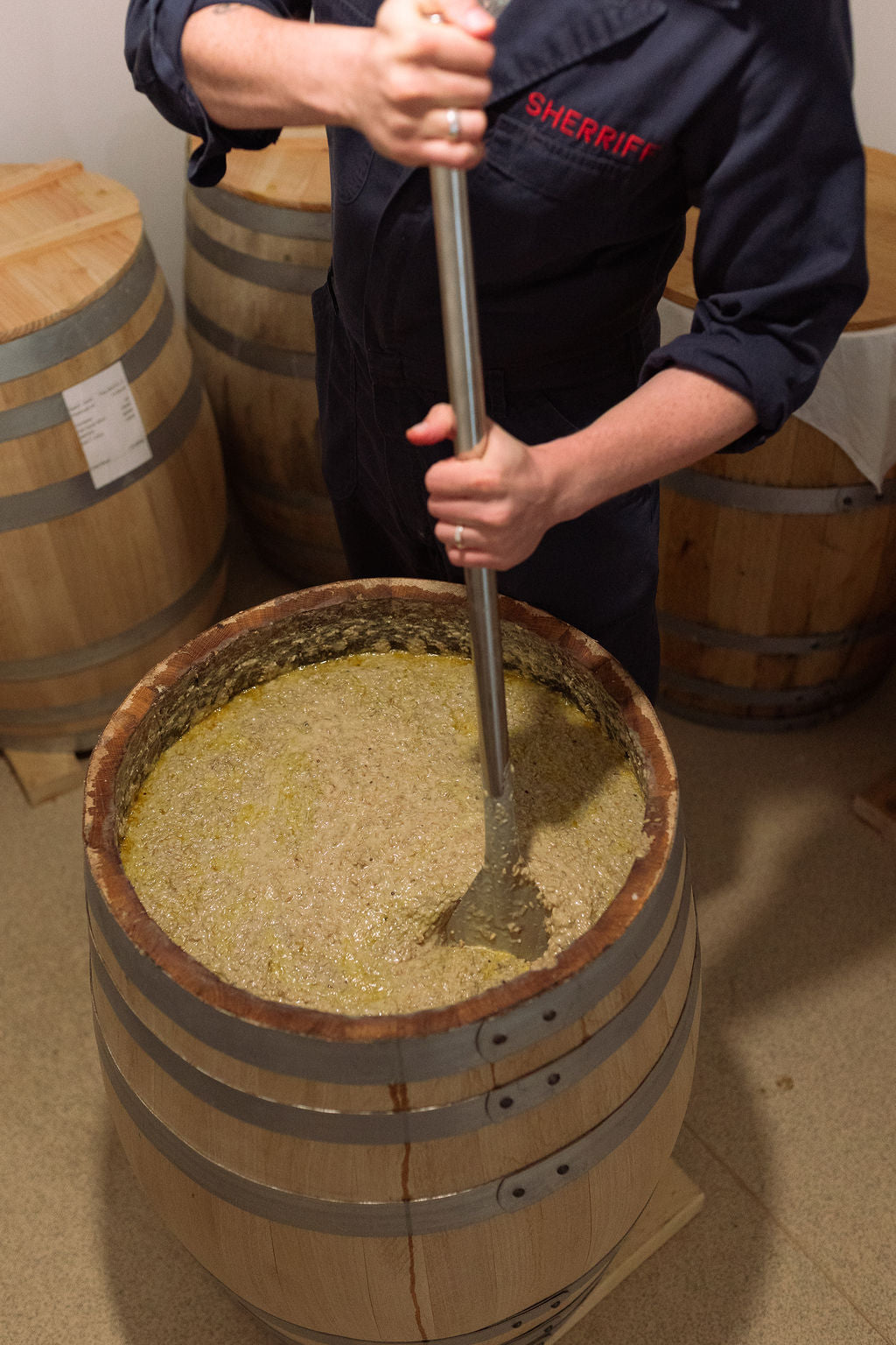 Robin Sherriff stirring a barrel of fermenting miso mash with a long paddle.